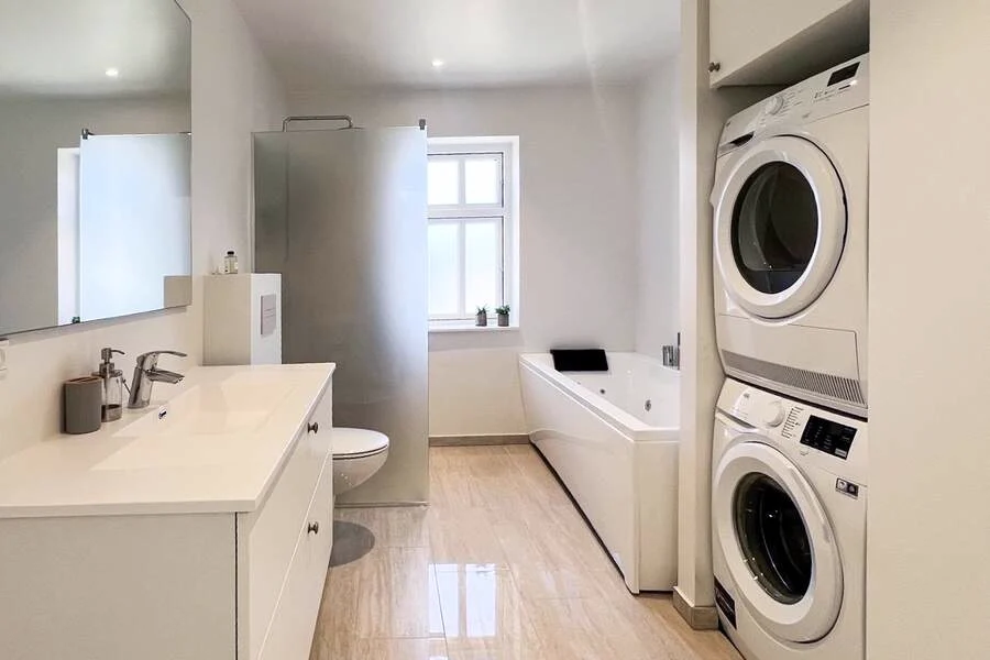 Masterbadeværelset med jacuzzi, bruser samt vaskemaskine og tørretumbler