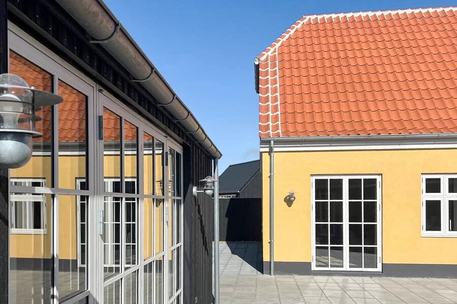 Den gule facade ned mod den overdækkede terrasse