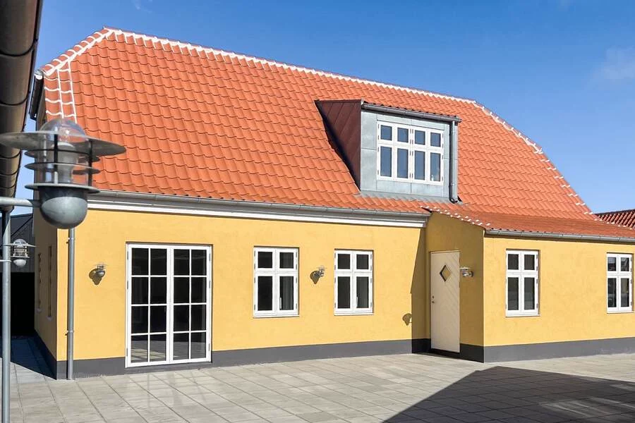 Det gule skagenhus med rødt tegl og hvid bordur